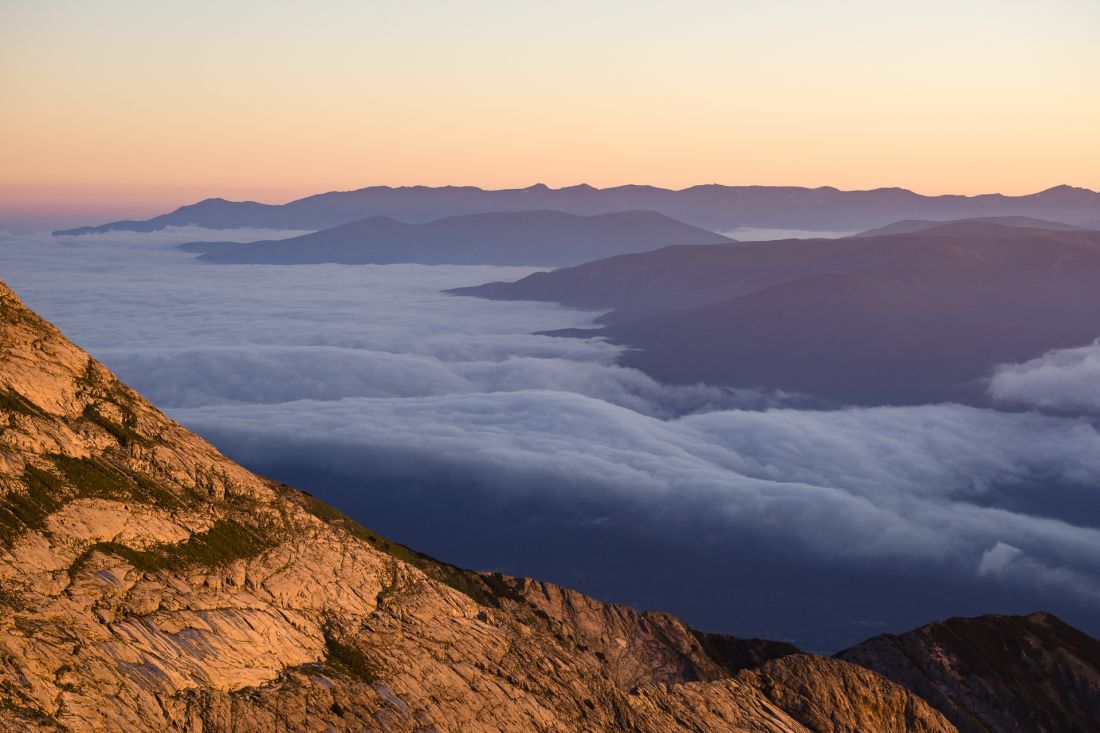 Peaks of Rila mountains rising above cloudy oceans